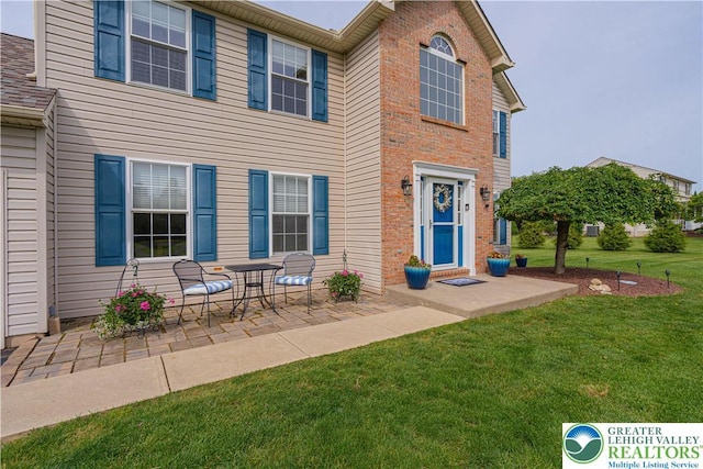 3624 Mcintosh Dr, North Whitehall Twp, PA 18069 - view of front of property with a front yard, a patio, and brick siding