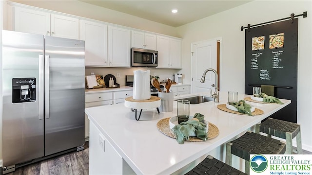 311 Knollwood Dr, Forks Twp, PA 18040 - kitchen featuring appliances with stainless steel finishes, white cabinetry, a sink, a kitchen breakfast bar, and wood finished floors