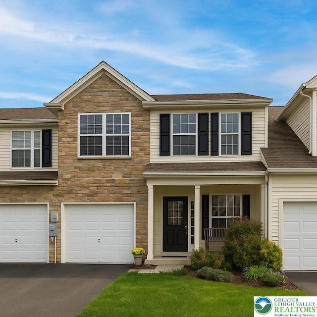 27 Willow Dr, Palmer Twp, PA 18045 - view of front of home featuring stone siding, driveway, an attached garage, covered porch, and roof with shingles