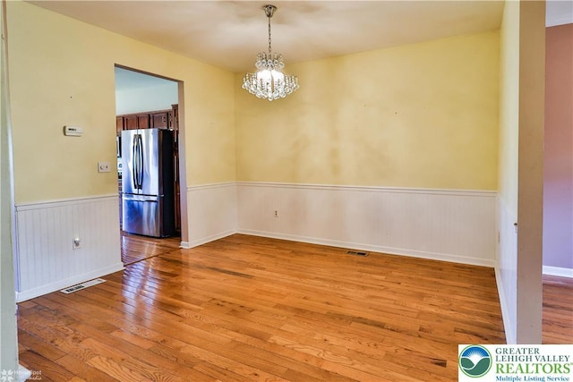 27 Willow Dr, Palmer Twp, PA 18045 - unfurnished room featuring light wood-style flooring, wainscoting, and a chandelier