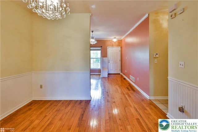 27 Willow Dr, Palmer Twp, PA 18045 - unfurnished dining area with a chandelier, light wood finished floors, crown molding, and wainscoting