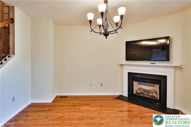 27 Willow Dr, Palmer Twp, PA 18045 - unfurnished living room featuring a chandelier, wood finished floors, a fireplace with flush hearth, and baseboards