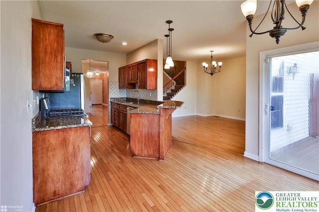 27 Willow Dr, Palmer Twp, PA 18045 - kitchen with a chandelier, a sink, tasteful backsplash, light wood-style floors, and brown cabinetry