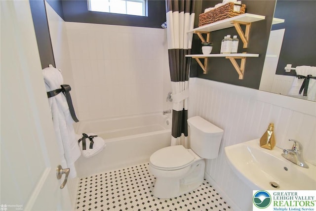 3420 Gentlewind Way Unit Ic 110, Emmaus Borough, PA 18049 - bathroom with toilet, wainscoting, shower / bath combo with shower curtain, a sink, and a decorative wall