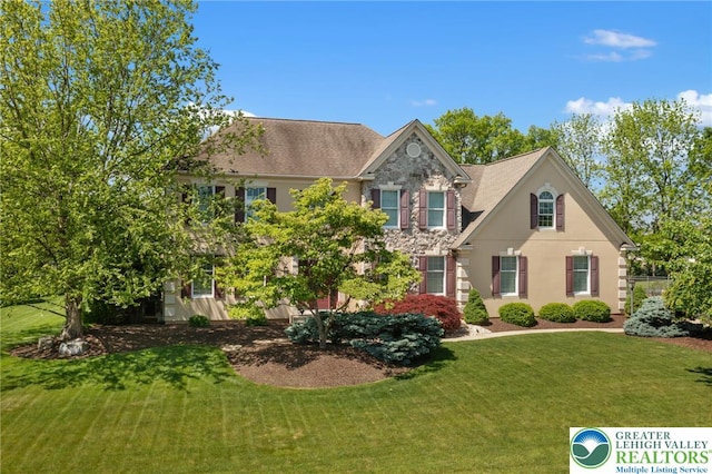 168 Forsythia Ln, Upper Macungie Twp, PA 18104 - view of front facade featuring a front yard, stone siding, and stucco siding