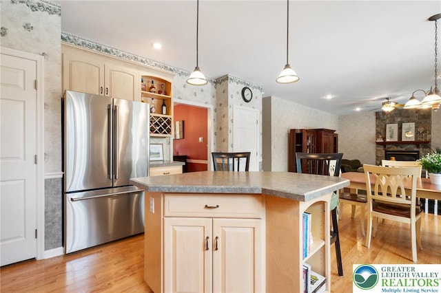 168 Forsythia Ln, Upper Macungie Twp, PA 18104 - kitchen with high end fridge, a stone fireplace, wallpapered walls, light wood finished floors, and ceiling fan