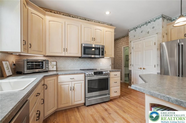168 Forsythia Ln, Upper Macungie Twp, PA 18104 - kitchen featuring appliances with stainless steel finishes, light brown cabinetry, wallpapered walls, light wood-type flooring, and backsplash