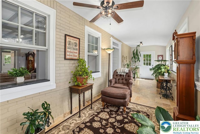 3139 Wilson Ave, Bethlehem Twp, PA 18020 - living area with brick wall, stone tile floors, ceiling fan, and vaulted ceiling