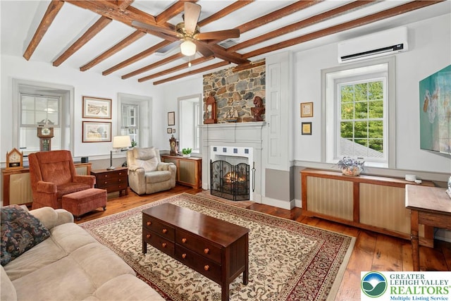 3139 Wilson Ave, Bethlehem Twp, PA 18020 - living room featuring an AC wall unit, wood finished floors, a ceiling fan, beam ceiling, and a fireplace