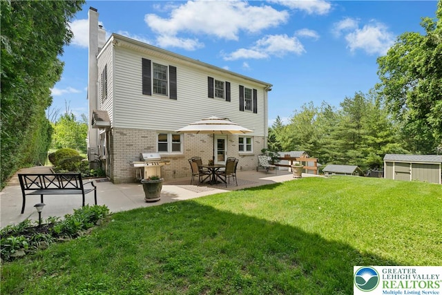3139 Wilson Ave, Bethlehem Twp, PA 18020 - back of property with brick siding, a chimney, a lawn, and a patio