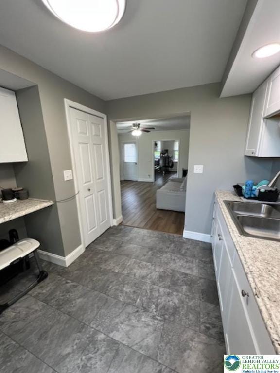 416 White St, Bowmanstown Borough, PA 18071 - kitchen with baseboards, white cabinetry, a sink, ceiling fan, and light countertops