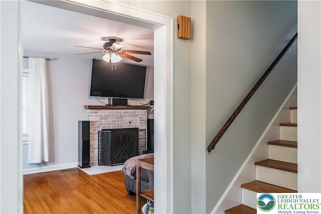 631 Main St, Tatamy Borough, PA 18085 - stairway with a ceiling fan, wood finished floors, a brick fireplace, and baseboards