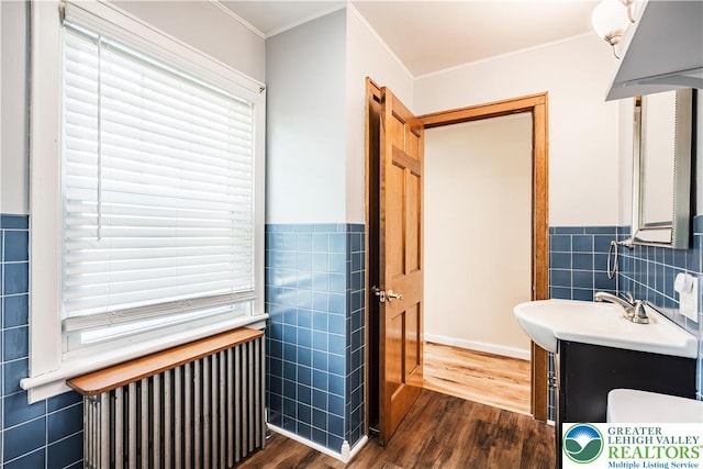 631 Main St, Tatamy Borough, PA 18085 - bathroom with tile walls, radiator, wood finished floors, crown molding, and vanity