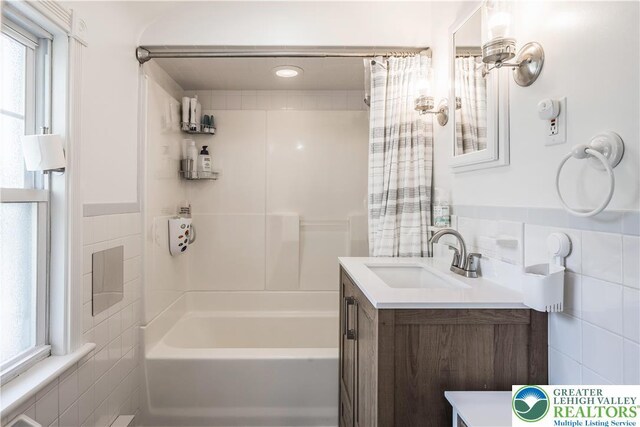 631 Main St, Tatamy Borough, PA 18085 - bathroom with tile walls, vanity, shower / bathtub combination with curtain, and plenty of natural light