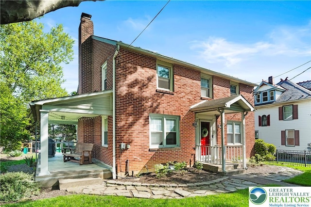 631 Main St, Tatamy Borough, PA 18085 - view of front facade with a chimney, brick siding, and covered porch