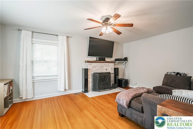 631 Main St, Tatamy Borough, PA 18085 - living area with ceiling fan, wood finished floors, a brick fireplace, and baseboards