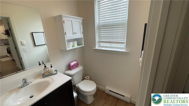 331 Minor St, Emmaus Borough, PA 18049 - half bathroom featuring a baseboard radiator, toilet, vanity, wood finished floors, and baseboards