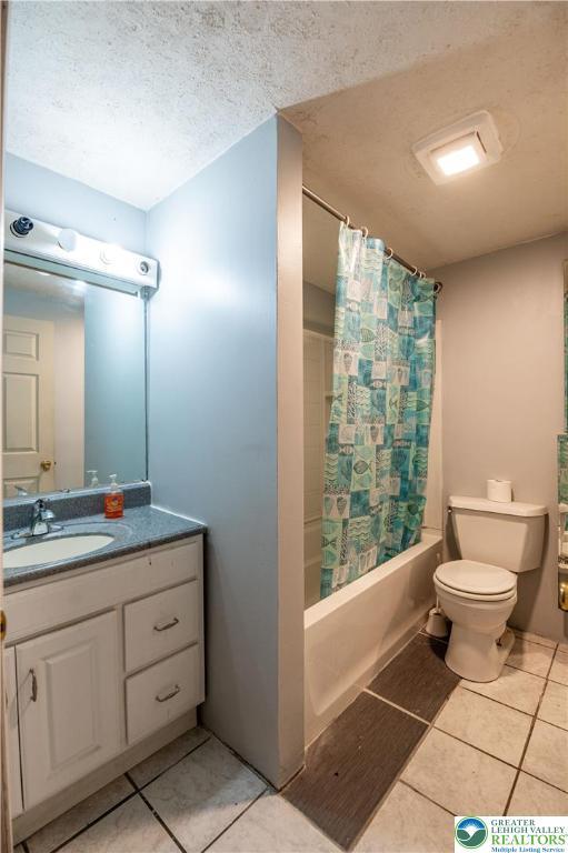 2107 3rd St, Bethlehem Twp, PA 18020 - full bathroom with tile patterned flooring, toilet, vanity, shower / bath combo, and a textured ceiling