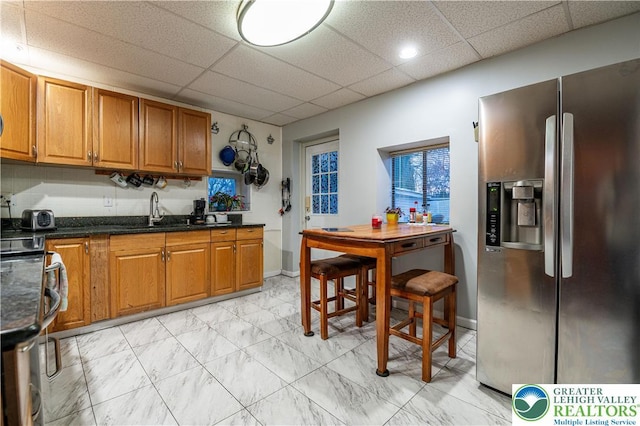 2107 3rd St, Bethlehem Twp, PA 18020 - kitchen with stainless steel fridge with ice dispenser, a sink, brown cabinets, a drop ceiling, and range