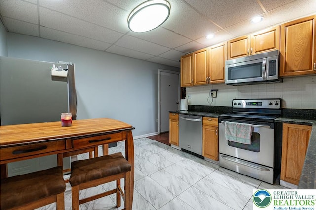 2107 3rd St, Bethlehem Twp, PA 18020 - kitchen with stainless steel appliances, dark countertops, a paneled ceiling, light marble finish flooring, and recessed lighting
