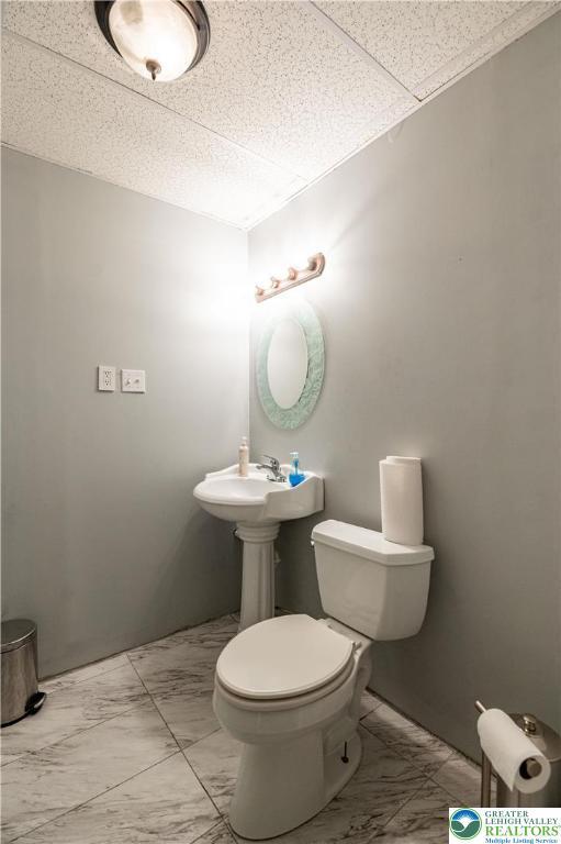 2107 3rd St, Bethlehem Twp, PA 18020 - half bathroom with marble look tiles and toilet