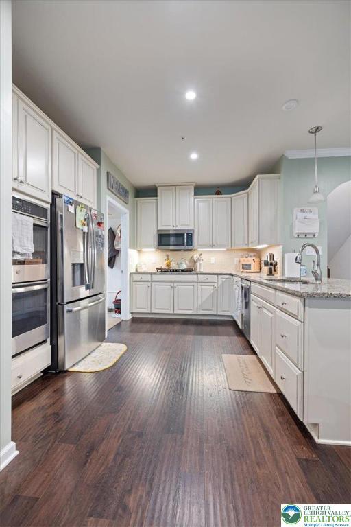 2585 Raya Way, Bethlehem Twp, PA 18045 - kitchen featuring appliances with stainless steel finishes, a peninsula, white cabinets, dark wood-style floors, and recessed lighting
