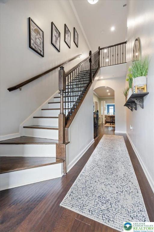 2585 Raya Way, Bethlehem Twp, PA 18045 - staircase featuring arched walkways, wood finished floors, baseboards, and a high ceiling