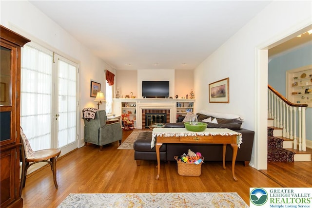 215 S 22nd St, Allentown City, PA 18104 - living room with wood finished floors, stairway, and a brick fireplace