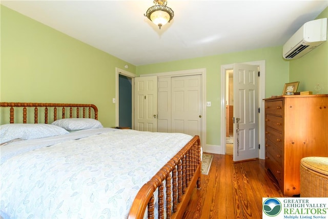 215 S 22nd St, Allentown City, PA 18104 - bedroom with an AC wall unit, wood finished floors, a closet, and baseboards