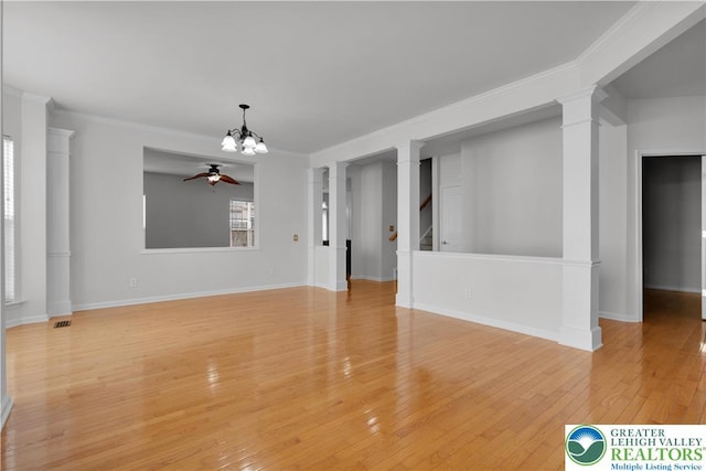 8604 Cascade Rd, Upper Macungie Twp, PA 18031 - unfurnished living room featuring a ceiling fan, ornate columns, light wood-style flooring, crown molding, and a chandelier