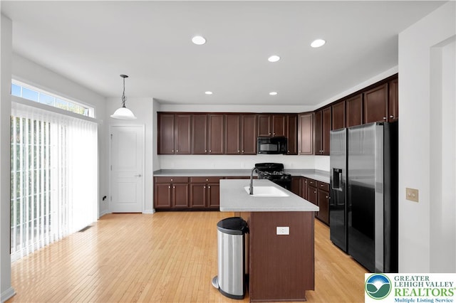8604 Cascade Rd, Upper Macungie Twp, PA 18031 - kitchen featuring black appliances, a sink, light wood-type flooring, light countertops, and dark brown cabinets