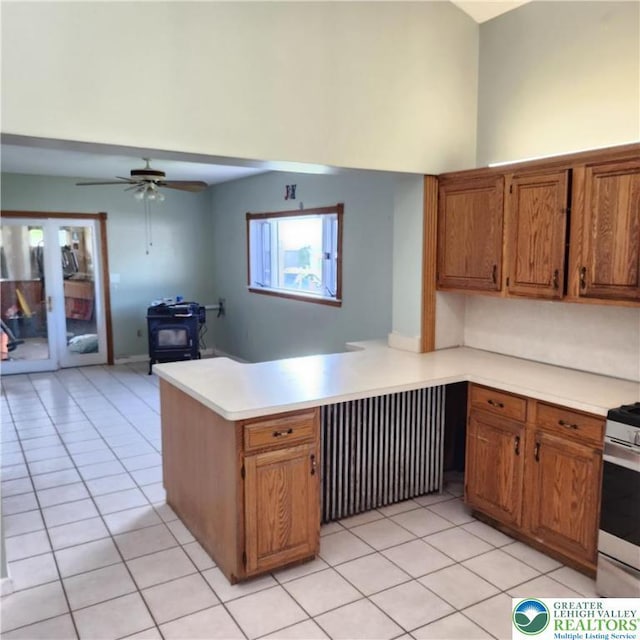 2357 Spring St, North Whitehall Twp, PA 18037 - kitchen featuring radiator, light tile patterned floors, a peninsula, light countertops, and a wood stove