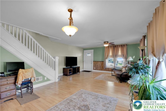 622 Scholl Ave, Salisbury Twp, PA 18015 - living area featuring stairway, wood finished floors, a wainscoted wall, a ceiling fan, and baseboards