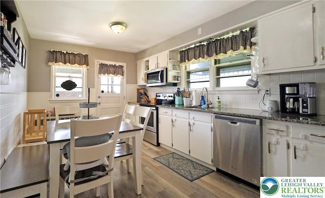 613 S Hoffert St, Fountain Hill Boro, PA 18015 - kitchen featuring appliances with stainless steel finishes, a sink, light wood-style flooring, white cabinetry, and dark stone countertops