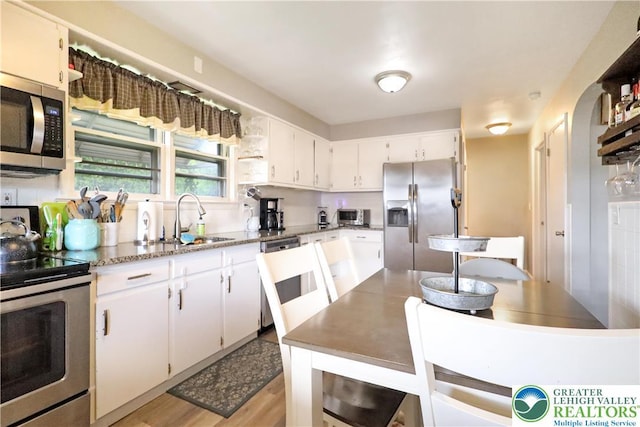 613 S Hoffert St, Fountain Hill Boro, PA 18015 - kitchen with stainless steel appliances, a sink, white cabinets, light stone countertops, and light wood-type flooring