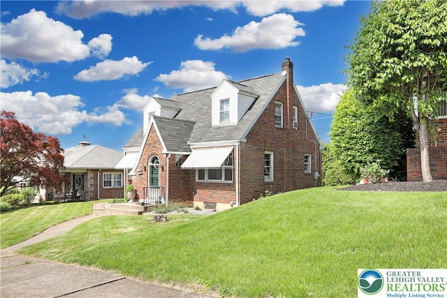 613 S Hoffert St, Fountain Hill Boro, PA 18015 - view of front facade featuring brick siding, a front yard, roof with shingles, and a chimney