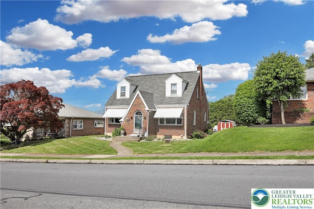 613 S Hoffert St, Fountain Hill Boro, PA 18015 - view of front of property featuring brick siding, a front lawn, a chimney, and a storage unit