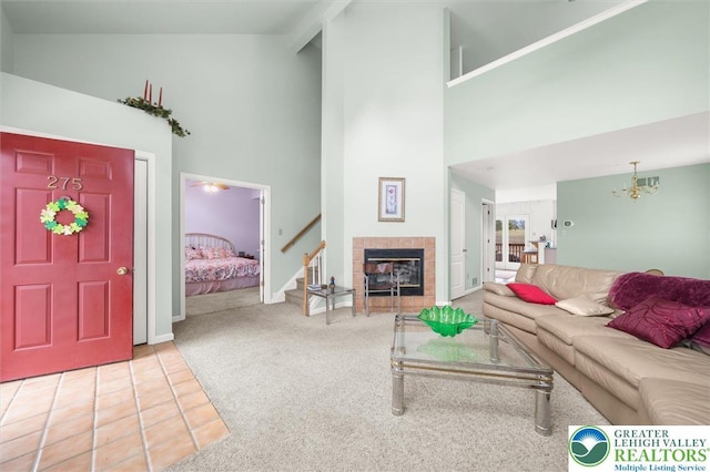275 Ridings Cir, Macungie Borough, PA 18062 - carpeted living room featuring high vaulted ceiling, stairway, a chandelier, tile patterned floors, and a fireplace
