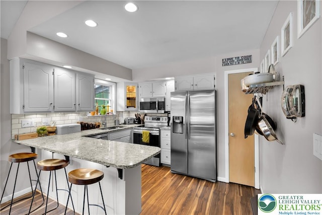 5401 Hale Ave, Hanover Twp, PA 18017 - kitchen with stainless steel appliances, a peninsula, a sink, tasteful backsplash, and a kitchen breakfast bar