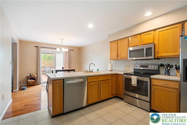 2630 Lower Way, Forks Twp, PA 18040 - kitchen featuring appliances with stainless steel finishes, a sink, a peninsula, light countertops, and a chandelier