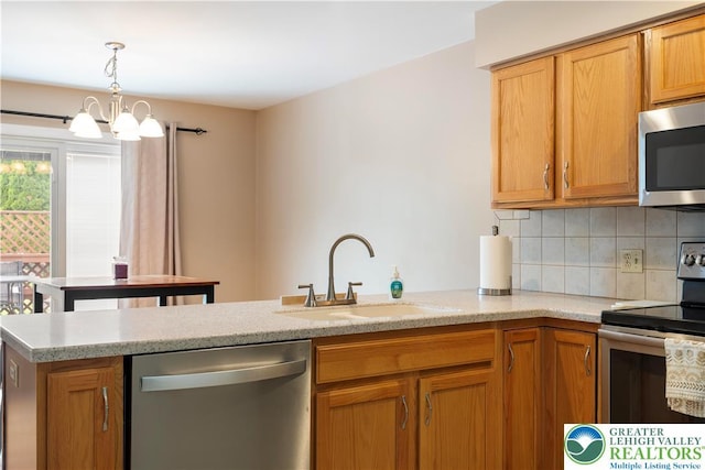 2630 Lower Way, Forks Twp, PA 18040 - kitchen with appliances with stainless steel finishes, a sink, tasteful backsplash, a peninsula, and decorative light fixtures