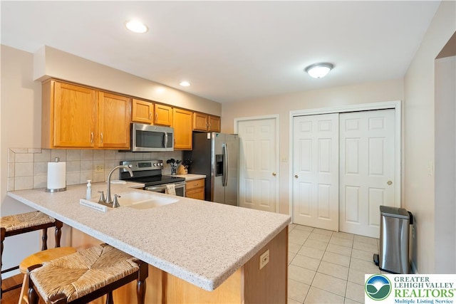 2630 Lower Way, Forks Twp, PA 18040 - kitchen with stainless steel appliances, a sink, a peninsula, decorative backsplash, and light tile patterned floors