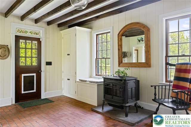 408 Kintner Hill Rd, Nockamixon Twp, PA 18972 - entrance foyer with a wood stove, brick patterned flooring, plenty of natural light, beamed ceiling, and a decorative wall