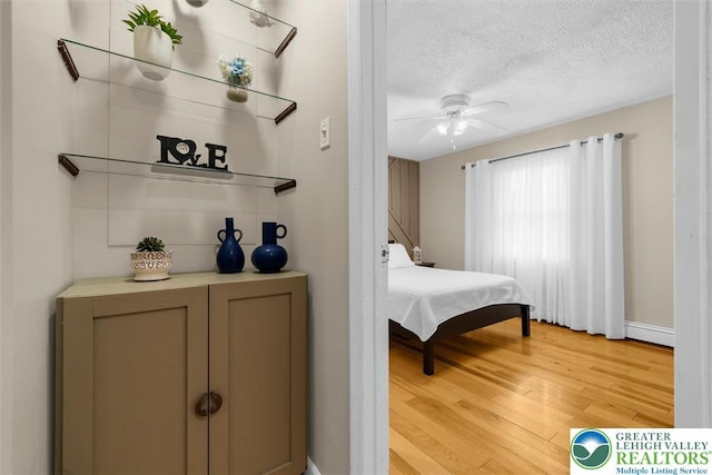 3079 Eldridge Ave, Palmer Twp, PA 18045 - bedroom with a baseboard radiator, light wood-style flooring, a textured ceiling, baseboards, and ceiling fan