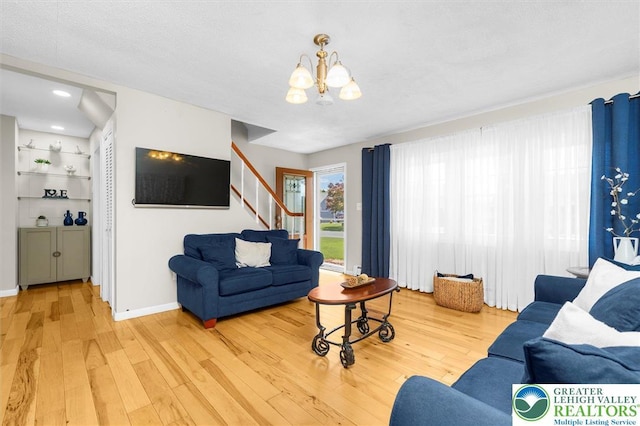 3079 Eldridge Ave, Palmer Twp, PA 18045 - living area featuring light wood finished floors, a chandelier, stairway, and baseboards