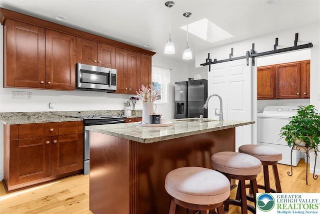 3079 Eldridge Ave, Palmer Twp, PA 18045 - kitchen with stainless steel appliances, washer / clothes dryer, light wood finished floors, and a skylight