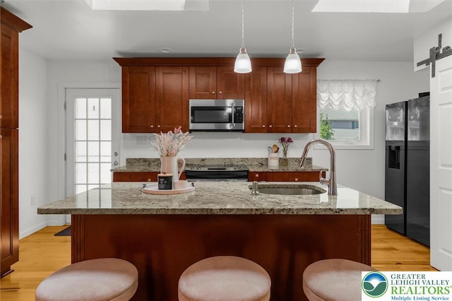 3079 Eldridge Ave, Palmer Twp, PA 18045 - kitchen featuring appliances with stainless steel finishes, a sink, light wood-style flooring, and a breakfast bar area