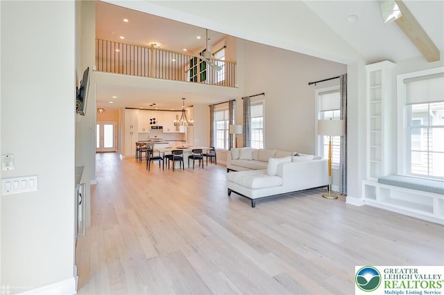 3896 Independence Dr, Easton, PA 18045 - living room with light wood finished floors, high vaulted ceiling, plenty of natural light, a chandelier, and baseboards