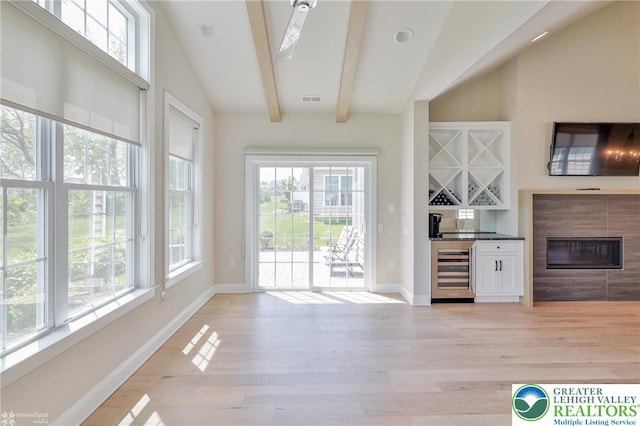3896 Independence Dr, Easton, PA 18045 - unfurnished living room featuring healthy amount of natural light, light wood-style floors, wine cooler, and a dry bar