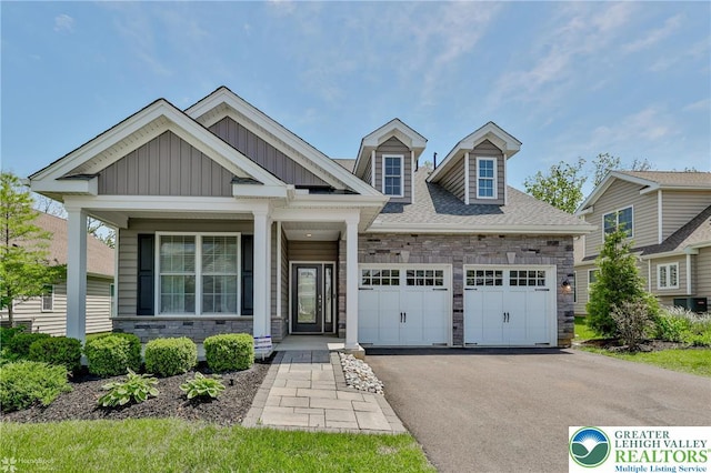 3896 Independence Dr, Easton, PA 18045 - view of front of property featuring stone siding, an attached garage, board and batten siding, driveway, and covered porch